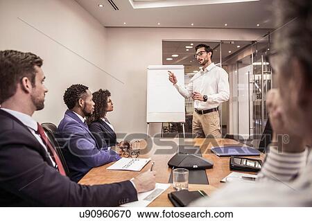 Business team listening to flipchart presentation at boardroom table View Large Photo Image Stock Image - Business team listening to flipchart presentation at boardroom table. Fotosearch