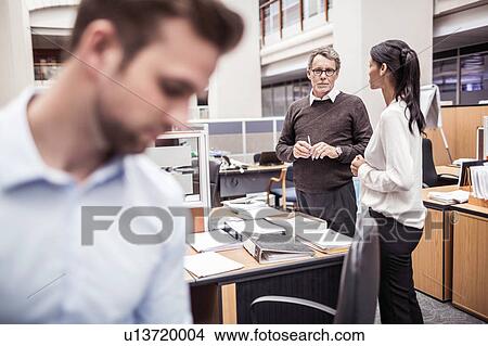 Businessman and woman having discussion in office View Large Photo Image Picture - Businessman and woman having discussion in office. Fotosearch