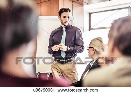 Stock Image - Businessman being questioned at boardroom presentation. Fotosearch