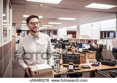 Businessman carrying package in office View Large Photo Image Stock Photograph - Businessman carrying package in office. Fotosearch