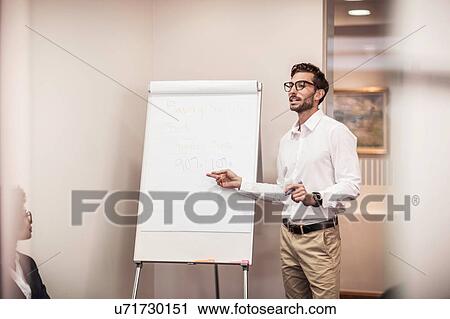 Businessman doing flipchart presentation in office View Large Photo Image Stock Image - Businessman doing flipchart presentation in office. Fotosearch