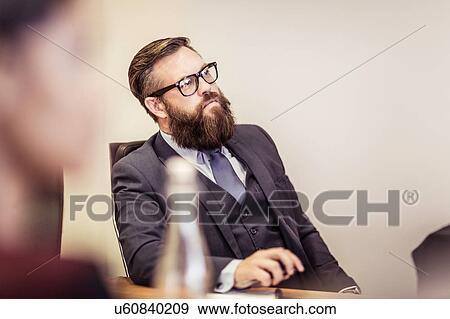 Businessman listening at boardroom meeting View Large Photo Image Stock Photo - Businessman listening at boardroom meeting. Fotosearch