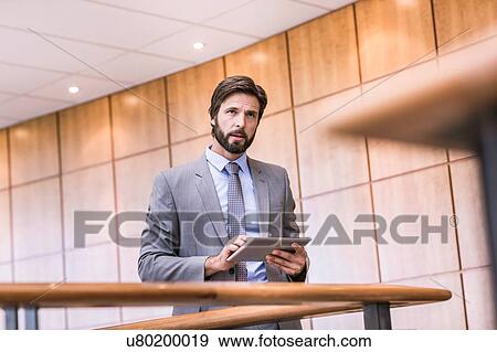 Businessman using digital tablet touchscreen on office balcony View Large Photo Image Stock Photo - Businessman using digital tablet touchscreen on office balcony. Fotosearch