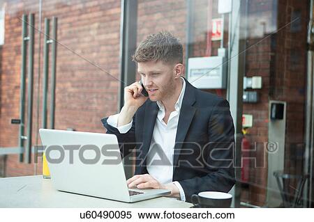 Stock Photography - Businessman working with laptop in cafe. Fotosearch