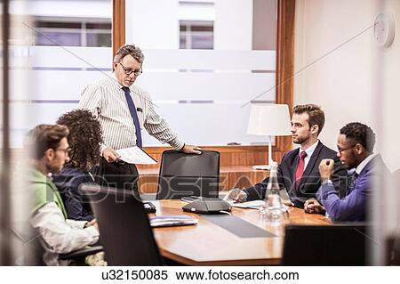Businessmen and woman having discussion at boardroom table meeting View Large Photo Image Stock Photography - Businessmen and woman having discussion at boardroom table meeting. Fotosearch