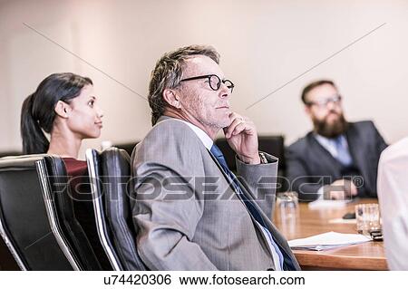 Stock Photograph - Businessmen and woman in board team meeting. Fotosearch