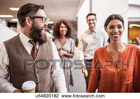 Businessmen and women walking and talking in office View Large Photo Image Stock Image - Businessmen and women walking and talking in office. Fotosearch