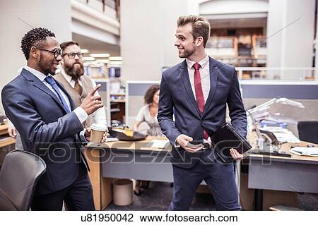 Businessmen walking and talking in office View Large Photo Image Stock Image - Businessmen walking and talking in office. Fotosearch