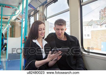 Businesswoman and businessman using digital tablet in Docklands Light Railway train, London View Large Photo Image Stock Image - Businesswoman and businessman using digital tablet in Docklands Light Railway train, London. Fotosearch