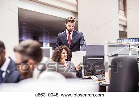Businesswoman and man reading paperwork at office desk View Large Photo Image Stock Photo - Businesswoman and man reading paperwork at office desk. Fotosearch