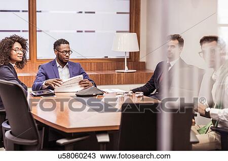 Businesswoman and men having discussion at boardroom table meeting View Large Photo Image Stock Image - Businesswoman and men having discussion at boardroom table meeting. Fotosearch