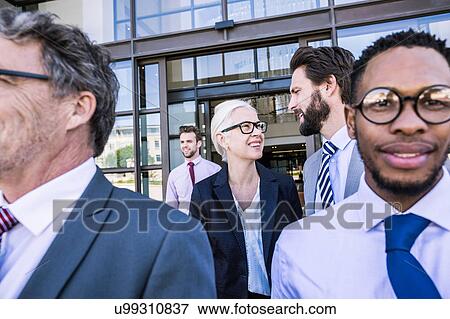 Stock Photo - Businesswoman and men leaving office building. Fotosearch