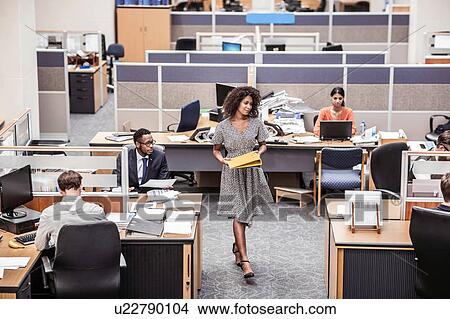 Businesswoman carrying files in office View Large Photo Image Picture - Businesswoman carrying files in office. Fotosearch