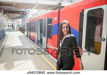 Stock Image - Businesswoman in Docklands Light Railway train, London. Fotosearch