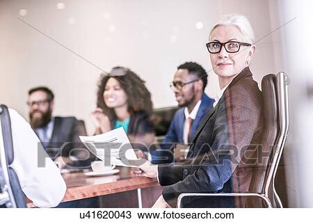 Businesswoman looking over her shoulder in board team meeting View Large Photo Image Stock Image - Businesswoman looking over her shoulder in board team meeting. Fotosearch