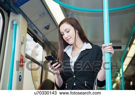 Businesswoman using cellphone in Docklands Light Railway train, London View Large Photo Image Stock Image - Businesswoman using cellphone in Docklands Light Railway train, London. Fotosearch