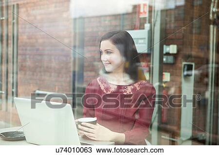 Stock Image - Businesswoman working with laptop in cafe. Fotosearch