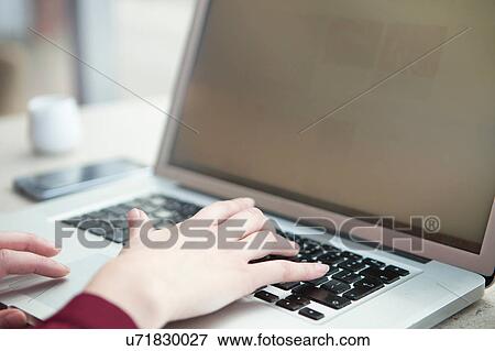Stock Photo - Businesswoman working with laptop in cafe. Fotosearch