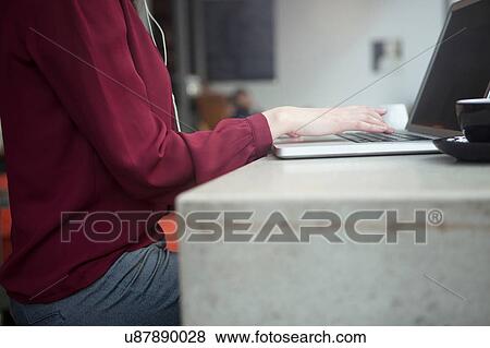 Stock Photo - Businesswoman working with laptop in cafe. Fotosearch