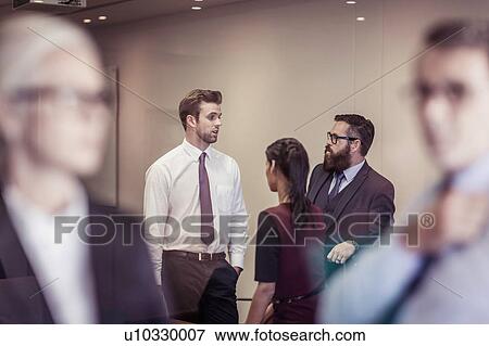 Businesswomen and men chatting in boardroom View Large Photo Image Stock Photo - Businesswomen and men chatting in boardroom. Fotosearch