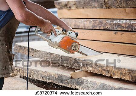 Carpenter sawing wooden plank View Large Photo Image Picture - Carpenter sawing wooden plank. Fotosearch