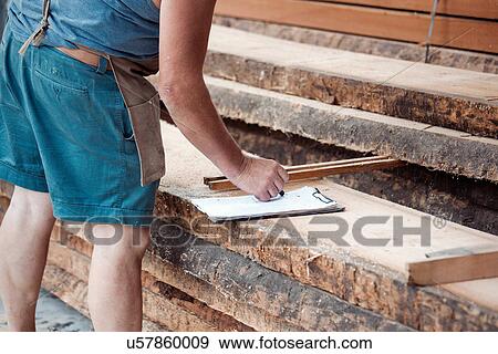 Stock Photo - Carpenter working in workshop. Fotosearch