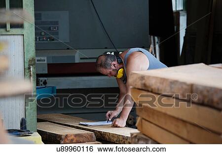 Stock Photograph - Carpenter working in workshop. Fotosearch