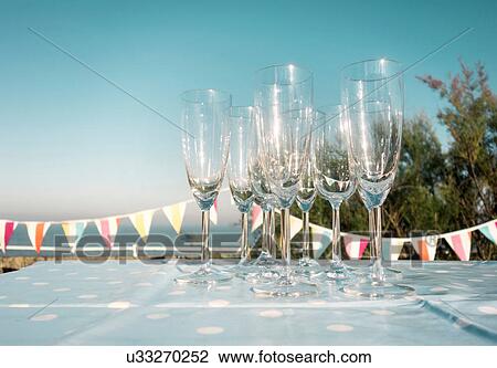 Stock Image - Champagne flutes on table at party. Fotosearch