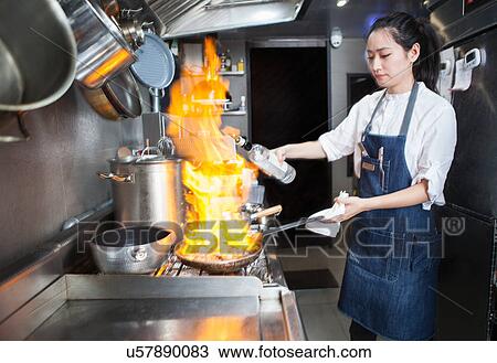 Chef flambeing in commercial kitchen View Large Photo Image Stock Image - Chef flambeing in commercial kitchen. Fotosearch