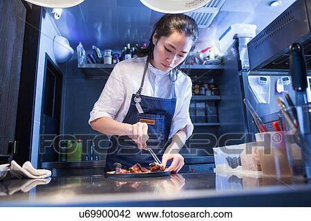 Chef in commercial kitchen preparing food View Large Photo Image Stock Image - Chef in commercial kitchen preparing food. Fotosearch