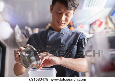 Chef in commercial kitchen preparing food View Large Photo Image Stock Photo - Chef in commercial kitchen preparing food. Fotosearch