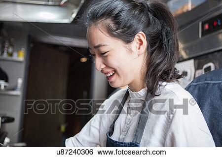 Stock Photograph - Chef in commercial kitchen smiling. Fotosearch