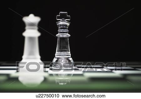 Stock Image - Chess queen and king on chess board. Fotosearch
