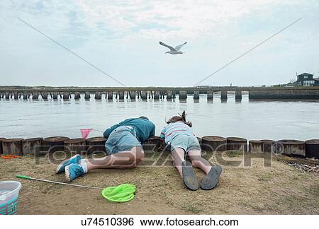 Children looking over side of pier into water, Southwold, Suffolk, UK View Large Photo Image Stock Photograph - Children looking over side of pier into water, Southwold, Suffolk, UK. Fotosearch
