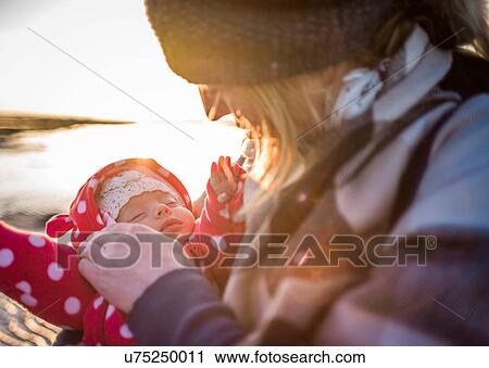 Stock Image - Close up of mother soothing baby girl. Fotosearch