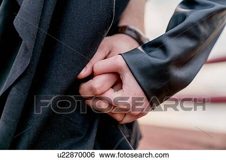 Stock Photograph - Close up of young couple hand in hand. Fotosearch