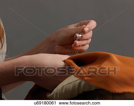 Close up of young female designer's hands sewing orange fabric View Large Photo Image Stock Image - Close up of young female designer's hands sewing orange fabric. Fotosearch