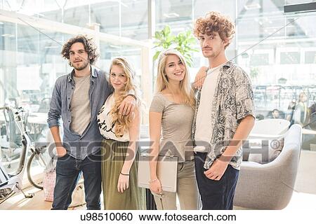 Co-workers standing in open plan office View Large Photo Image Stock Image - Co-workers standing in open plan office. Fotosearch