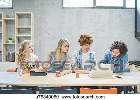 Co-workers working in open plan office View Large Photo Image Stock Image - Co-workers working in open plan office. Fotosearch