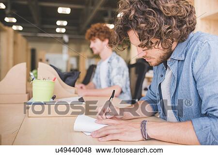 Stock Photo - Co-workers working in open plan office. Fotosearch