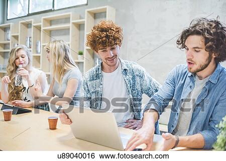 Co-workers working in open plan office View Large Photo Image Stock Photograph - Co-workers working in open plan office. Fotosearch
