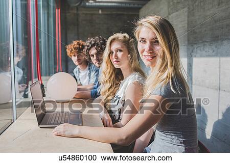 Co-workers working on laptop beside bar counter by window View Large Photo Image Stock Image - Co-workers working on laptop beside bar counter by window. Fotosearch