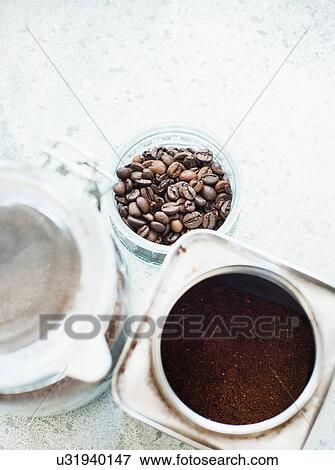 Stock Photo - Coffee beans and coffee grounds in caddy. Fotosearch