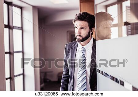 Confident businessman waiting at office doorway View Large Photo Image Stock Photography - Confident businessman waiting at office doorway. Fotosearch