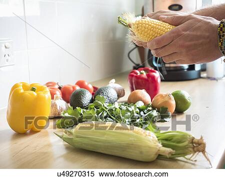 Stock Photography - Corn and vegetables on table. Fotosearch