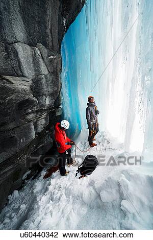 Stock Image - Couple in cave ice climbing, Saas Fee, Switzerland. Fotosearch