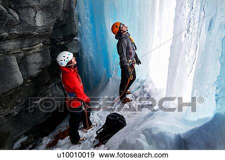 Stock Photo - Couple in cave ice climbing, Saas Fee, Switzerland. Fotosearch