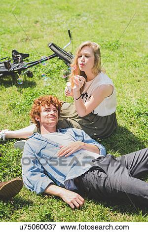 Stock Photo - Couple relaxing in park. Fotosearch