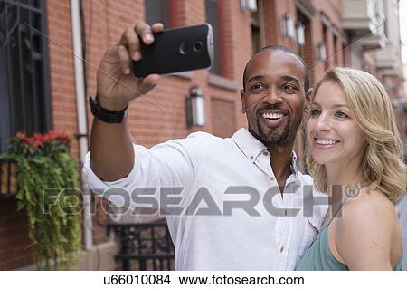 Picture - Couple taking selfie. Fotosearch