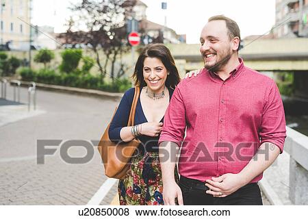 Couple walking on sidewalk View Large Photo Image Stock Photo - Couple walking on sidewalk. Fotosearch